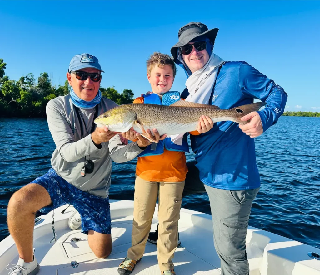 Family fishing charter in Punta Gorda holding a big snook on the boat
